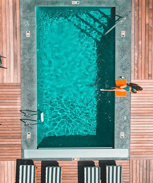 Beautiful woman sunbathing alone in swimming pool